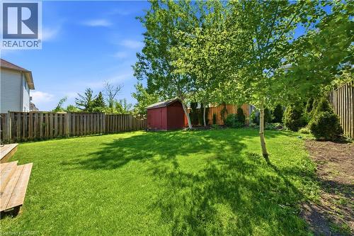 Expansive backyard featuring a manicured lawn, established trees, and a wooden privacy fence - 784 Butternut Avenue, Waterloo, ON - Outdoor