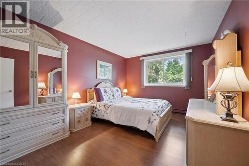 Wood-finish flooring with a textured ceiling and a window - 6 Walton Avenue Unit# 107, Kitchener, ON - Indoor Photo Showing Bedroom