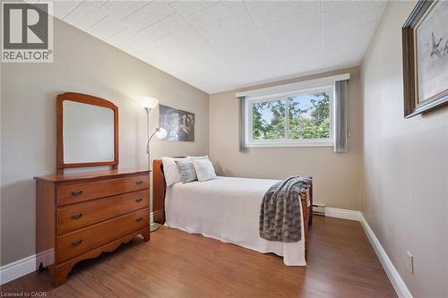 Wood-finish flooring with crisp white baseboards - 6 Walton Avenue Unit# 107, Kitchener, ON - Indoor Photo Showing Bedroom