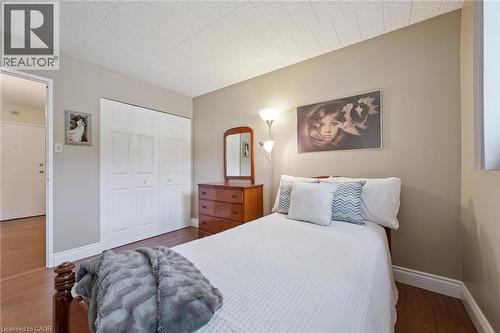 Wood-finish flooring with white trim - 6 Walton Avenue Unit# 107, Kitchener, ON - Indoor Photo Showing Bedroom