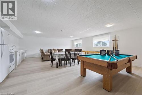 Spacious recreational area featuring light wood-finish flooring, recessed lighting, and multiple windows with roller blinds - 6 Walton Avenue Unit# 107, Kitchener, ON - Indoor Photo Showing Other Room