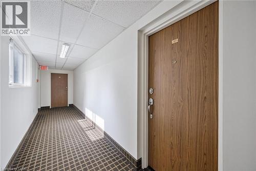 Wood-finish entry door with multiple locks and a peep-hole - 6 Walton Avenue Unit# 107, Kitchener, ON - Indoor Photo Showing Other Room