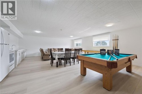Spacious recreational area featuring light wood-finish flooring, recessed lighting, and multiple windows with roller blinds - 6 Walton Avenue Unit# 107, Kitchener, ON - Indoor Photo Showing Other Room
