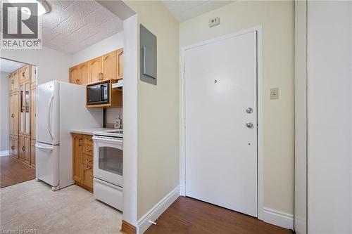 White front entry door with chrome hardware - 6 Walton Avenue Unit# 107, Kitchener, ON - Indoor Photo Showing Kitchen