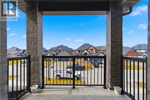 Expansive covered balcony with black metal railings offering panoramic vistas of the surrounding neighborhood - 2000 Maddex Way, London, ON - Outdoor