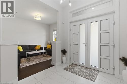 Bright, light-filled entry foyer featuring tile flooring, recessed ceiling lighting, and white paneled double doors with multiple glass panes - 2000 Maddex Way, London, ON - Indoor Photo Showing Other Room