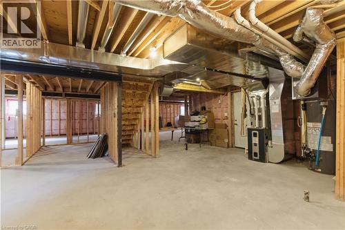 Unfinished basement with exposed wood-beam ceiling, concrete flooring, and ductwork infrastructure - 2000 Maddex Way, London, ON - Indoor Photo Showing Basement
