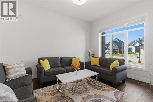 Bright, light-filled living room anchored by large glass doors and windows framing outdoor scenery - 2000 Maddex Way, London, ON - Indoor Photo Showing Living Room