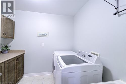 Laundry area with wood-finish cabinetry, light-toned countertop, and tile flooring - 1406 Marshall Crescent, Milton, ON - Indoor Photo Showing Laundry Room