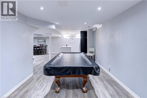 Spacious recreation area featuring wood-finish flooring, recessed lighting, and light grey walls - 1406 Marshall Crescent, Milton, ON - Indoor Photo Showing Other Room