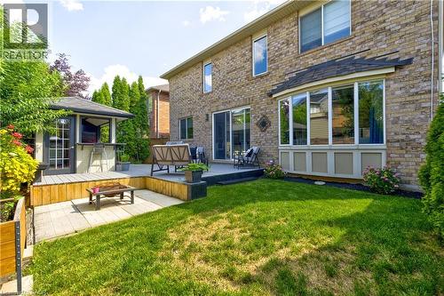 Brick exterior featuring a multi-level deck, a built-in gazebo with a bar, a bay window, and sliding glass doors - 1406 Marshall Crescent, Milton, ON - Outdoor With Deck Patio Veranda With Exterior