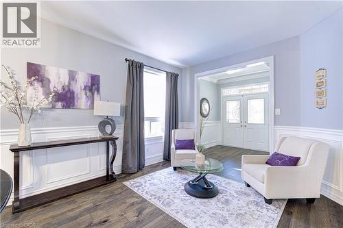 Living area with wood-finish flooring, wainscoting, and an archway leading to the entry - 1406 Marshall Crescent, Milton, ON - Indoor