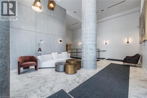 Lobby interior featuring large format marble-look flooring and a prominent exposed concrete column - 15 Wellington Street S Unit# 903, Kitchener, ON - Indoor Photo Showing Other Room