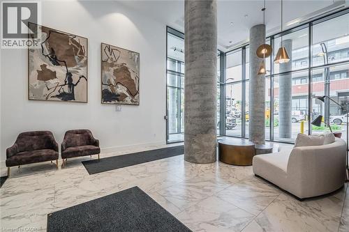 Spacious lobby featuring polished stone tile flooring, floor-to-ceiling windows, and concrete support columns - 15 Wellington Street S Unit# 903, Kitchener, ON - Indoor Photo Showing Other Room