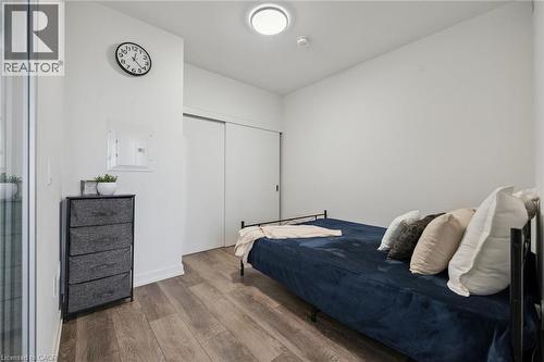 Compact bedroom featuring wood-finish flooring and white walls - 15 Wellington Street S Unit# 903, Kitchener, ON - Indoor Photo Showing Bedroom