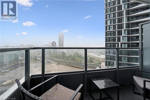 Private balcony featuring a glass and metal railing, concrete flooring, and urban landscape with distant city buildings - 15 Wellington Street S Unit# 903, Kitchener, ON - Outdoor With Balcony