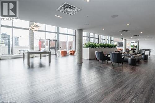 Spacious common area featuring extensive wood-finish flooring, floor-to-ceiling windows, and recessed lighting - 15 Wellington Street S Unit# 903, Kitchener, ON - Indoor