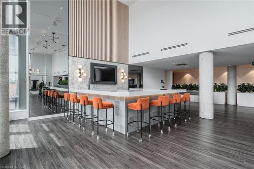 Open common area featuring a central bar with a light gray tile base and white countertop - 15 Wellington Street S Unit# 903, Kitchener, ON - Indoor