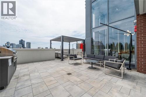 Expansive rooftop terrace featuring large format paver flooring, a built-in grill station, and a modern pergola structure - 15 Wellington Street S Unit# 903, Kitchener, ON - Outdoor