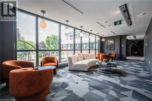 Expansive floor-to-ceiling windows illuminate this lounge area featuring contemporary ceiling-mounted light fixtures - 15 Wellington Street S Unit# 903, Kitchener, ON - Indoor
