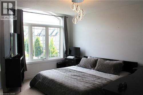 Arched transom window with mullioned panes, recessed lighting, and neutral wall color - 12 Poplar Drive Unit# 21, Cambridge, ON - Indoor Photo Showing Bedroom