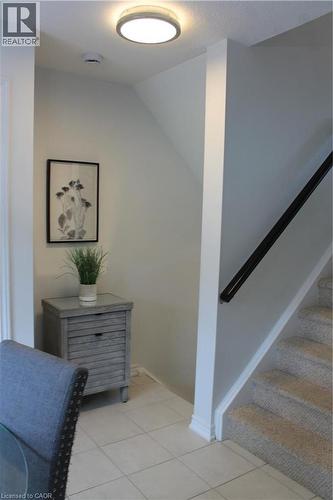 Recessed ceiling light, tiled flooring, carpeted stairs, and a dark handrail - 12 Poplar Drive Unit# 21, Cambridge, ON - Indoor Photo Showing Other Room