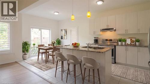 Kitchen with white cabinetry, stainless steel appliances, and a granite-finish island - 242 Moorlands Crescent, Kitchener, ON - Indoor
