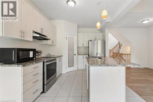 Kitchen featuring light-toned cabinetry, granite-patterned countertops, stainless steel appliances, a center island with a sink, and pendant lighting - 242 Moorlands Crescent, Kitchener, ON - Indoor Photo Showing Kitchen With Upgraded Kitchen