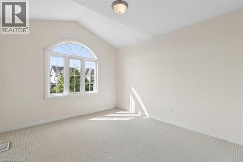 Vaulted ceiling, arched window, wall-to-wall carpeting, flush mount lighting, and neutral wall tones - 242 Moorlands Crescent, Kitchener, ON - Indoor Photo Showing Other Room