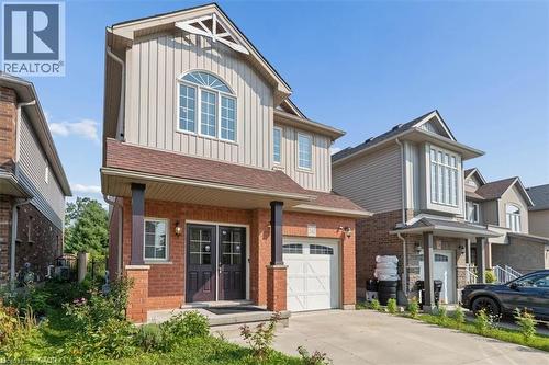 Brick and vertical siding exterior with an arched window accent - 242 Moorlands Crescent, Kitchener, ON - Outdoor With Facade