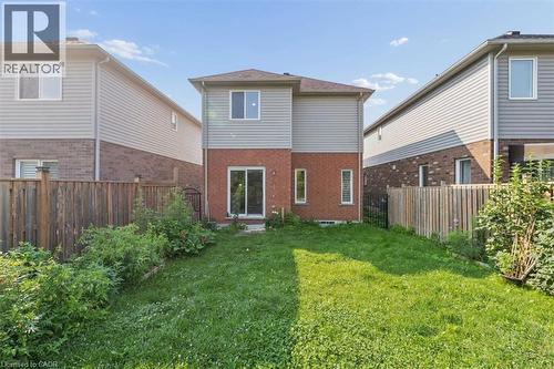 Expansive backyard featuring a grass lawn, privacy fencing, and a two-story exterior with brick and siding - 242 Moorlands Crescent, Kitchener, ON - Outdoor With Exterior