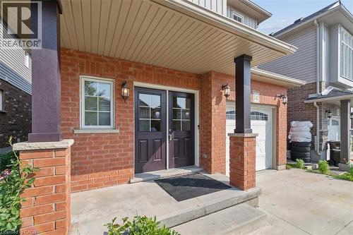 Brick exterior with a covered porch, twin entry doors, and an integrated garage - 242 Moorlands Crescent, Kitchener, ON - Outdoor With Exterior