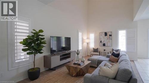 Vaulted ceiling, plantation shutters, wood-finish flooring, and light wall tones - 242 Moorlands Crescent, Kitchener, ON - Indoor Photo Showing Living Room