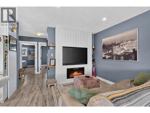 Inviting living room with a cozy fireplace and plenty of natural light. - 3703 Commonage Crescent, Vernon, BC - Indoor Photo Showing Living Room With Fireplace