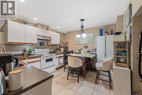 Kitchen with white upper and lower cabinetry, white appliances, and a tile backsplash - 4105 Ross Rd, Nanaimo, BC - Indoor