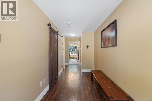 Hallway featuring wood-finish laminate flooring, a wood barn door, and recessed lighting - 4105 Ross Rd, Nanaimo, BC - Indoor Photo Showing Other Room