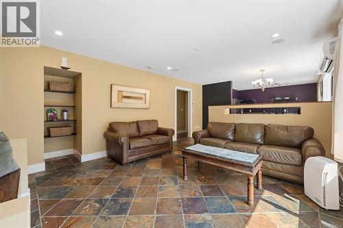Multi-toned tile flooring with a diagonal pattern and storage closet for games and blankets. - 4105 Ross Rd, Nanaimo, BC - Indoor Photo Showing Living Room