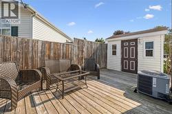 Wood deck with a detached storage shed and privacy fencing - 