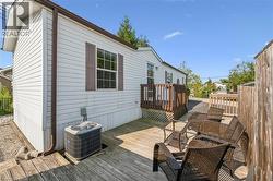 Exterior with white siding and brown shutters, featuring a wooden deck with railing - 