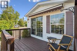 Exterior deck with wooden railing and brown-painted flooring - 