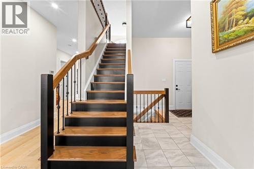 Staircase featuring wood treads, black risers, and wrought iron balusters - 130 Pondcliffe Drive, Kitchener, ON - Indoor Photo Showing Other Room