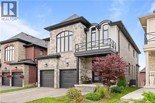 Contemporary stone and brick facade featuring a two-car garage with dark paneled doors - 130 Pondcliffe Drive, Kitchener, ON - Outdoor