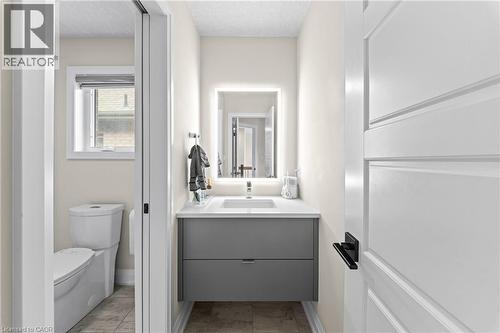 Modern powder room featuring a floating gray vanity with a white countertop and rectangular sink - 130 Pondcliffe Drive, Kitchener, ON - Indoor Photo Showing Bathroom