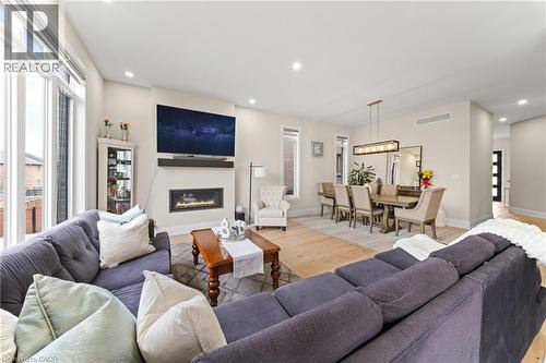 Open-concept living space featuring wood-finish flooring throughout, a gas fireplace with a mantel, and recessed lighting - 130 Pondcliffe Drive, Kitchener, ON - Indoor Photo Showing Living Room With Fireplace