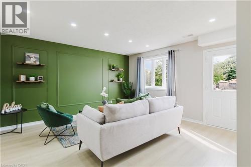 Recessed lighting illuminating a feature wall with decorative molding, light wood-finish flooring, and multiple windows - 67 Kinzie Avenue, Kitchener, ON - Indoor Photo Showing Living Room