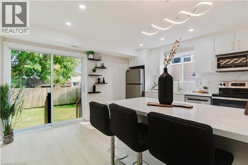 Kitchen with white cabinetry, stainless steel appliances, and a central island with seating - 67 Kinzie Avenue, Kitchener, ON - Indoor Photo Showing Kitchen