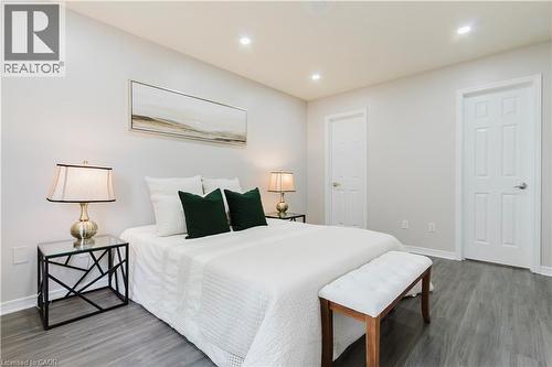 Neutral wall color, recessed ceiling lights, wood-finish flooring, and white paneled doors - 67 Kinzie Avenue, Kitchener, ON - Indoor Photo Showing Bedroom