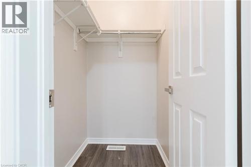 Closet with white wire shelving, hanging rod, wood-finish flooring, and white baseboards - 67 Kinzie Avenue, Kitchener, ON - Indoor With Storage