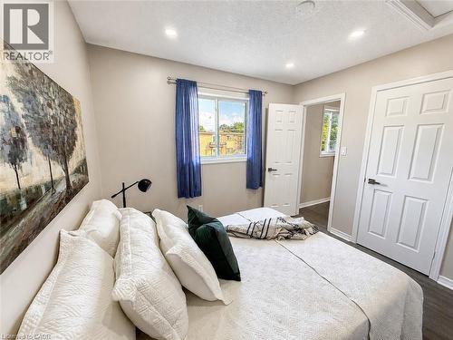 Recessed lighting, wood-finish flooring, white paneled doors, and a window with natural light - 67 Kinzie Avenue, Kitchener, ON - Indoor Photo Showing Bedroom