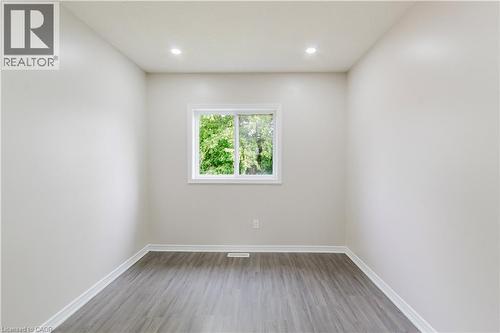 Recessed ceiling lighting, a white window frame, wood-finish flooring, and light-toned walls - 67 Kinzie Avenue, Kitchener, ON - Indoor Photo Showing Other Room